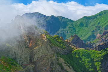 Nature scene of green mountains against cloudy blue sky