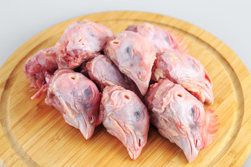 raw chicken heads on a white background