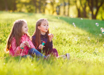 Girls play with soap bubbles.