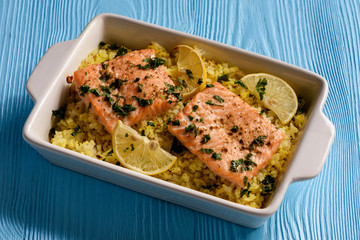 Salmon baked on oven with rice and lemon.
