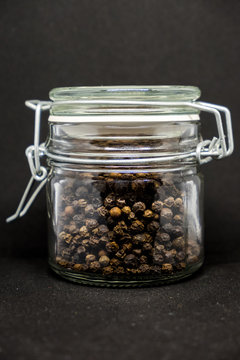 jar of pepper on a black background