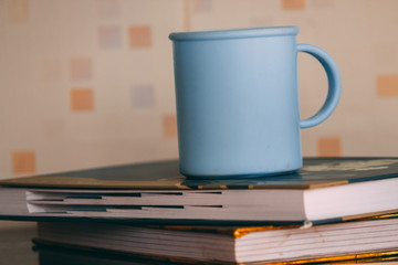 Naklejka premium Coffee mug on top of books