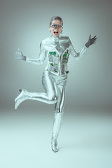 Fototapeta na wymiar full length view of silver woman robot screaming on grey, future technology concept