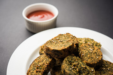Cilantro cake or Kothimbir Vadi is a popular maharashtrian cuisine made with cilantro leaves. served with tomato ketchup. selective focus