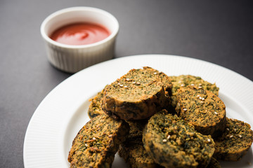 Cilantro cake or Kothimbir Vadi is a popular maharashtrian cuisine made with cilantro leaves. served with tomato ketchup. selective focus