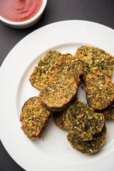 Cilantro cake or Kothimbir Vadi is a popular maharashtrian cuisine made with cilantro leaves. served with tomato ketchup. selective focus