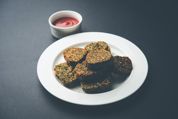 Cilantro cake or Kothimbir Vadi is a popular maharashtrian cuisine made with cilantro leaves. served with tomato ketchup. selective focus