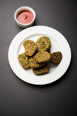 Cilantro cake or Kothimbir Vadi is a popular maharashtrian cuisine made with cilantro leaves. served with tomato ketchup. selective focus