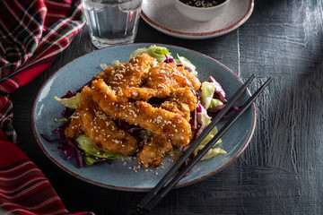 Salad with warm glazing chicken, sprinkled with sesame seeds. Chinese cuisine. Asian culture