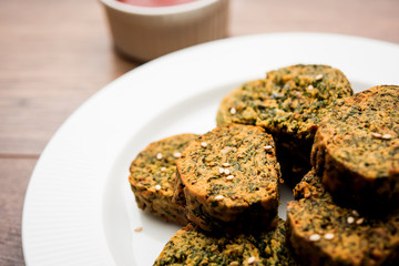 Cilantro cake or Kothimbir Vadi is a popular maharashtrian cuisine made with cilantro leaves. served with tomato ketchup. selective focus