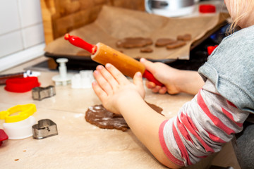 Little girl preparing a dough standing in the kitchen