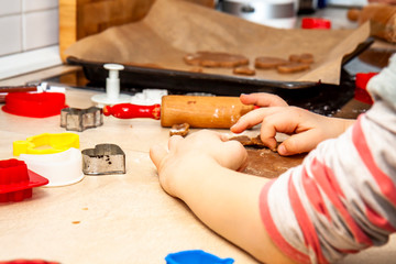Little girl preparing a dough standing in the kitchen