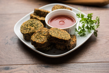 Cilantro cake or Kothimbir Vadi is a popular maharashtrian cuisine made with cilantro leaves. served with tomato ketchup. selective focus