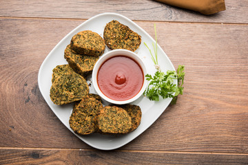 Cilantro cake or Kothimbir Vadi is a popular maharashtrian cuisine made with cilantro leaves. served with tomato ketchup. selective focus