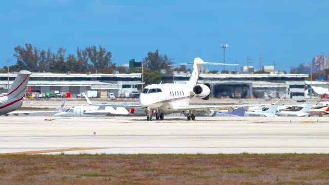 Generic Executive Private Business Jet Taxiing at an Airport Passing other Parked Airplanes on a Hot and Sunny Weather Day with Heat Haze