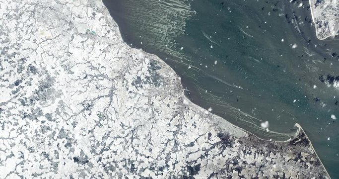 Vertical aerial ascent through light falling snow, over Chesapeake Bay, US east coast. Elements of this image furnished by NASA. 