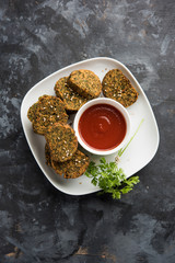 Cilantro cake or Kothimbir Vadi is a popular maharashtrian cuisine made with cilantro leaves. served with tomato ketchup. selective focus