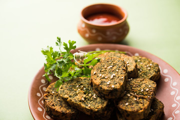 Cilantro cake or Kothimbir Vadi is a popular maharashtrian cuisine made with cilantro leaves. served with tomato ketchup. selective focus