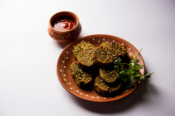 Cilantro cake or Kothimbir Vadi is a popular maharashtrian cuisine made with cilantro leaves. served with tomato ketchup. selective focus