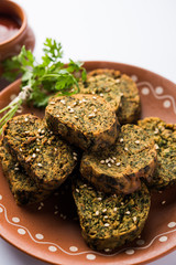 Cilantro cake or Kothimbir Vadi is a popular maharashtrian cuisine made with cilantro leaves. served with tomato ketchup. selective focus