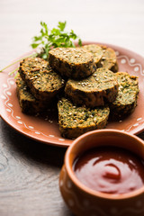 Cilantro cake or Kothimbir Vadi is a popular maharashtrian cuisine made with cilantro leaves. served with tomato ketchup. selective focus