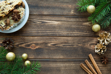 traditional Christmas cake, golden Christmas decorations, fir tree branches on brown wooden table.  Space for text.