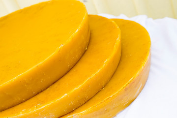 Pieces of fresh raw unprocessed but melted beeswax for making honey combs. 