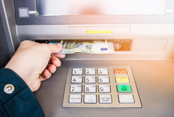 Happy person taking euro money from ATM bank machine. Payday concept.