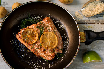 Gebratenes Lachsfilet in der Pfanne mit Sesamkörnern bestreut