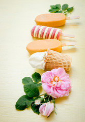 Variety of many different type and color ice creams on yellow background. Children kids hands taking ice creams, flat lay.