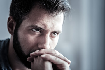Close up of handsome male that being deep in thoughts