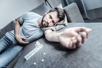Frustrated brunette man lying on his sofa