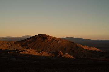 Naklejka na ściany i meble golden morning light on red earth hill, mountains, Eastern Sierra Nevada, California, USA