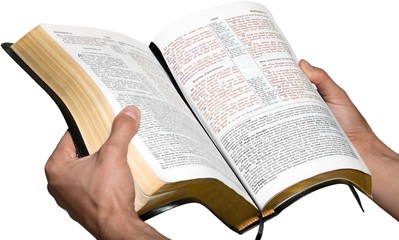 Fototapeta na wymiar Closeup on Hands Holding an Open Bible