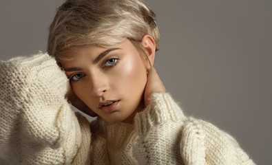 Portrait of natural beauty with blond short hair looking at camera isolated on gray background