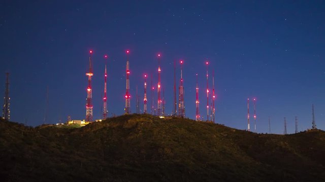 TV Antenna Signal Towers on Top of a Mountain at Night with Blinking Red Lights and a Starry Blue Sky Background near Phoenix Arizona