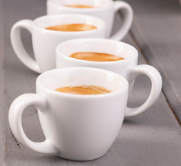 Чашки с эспрессо в ряд на столе