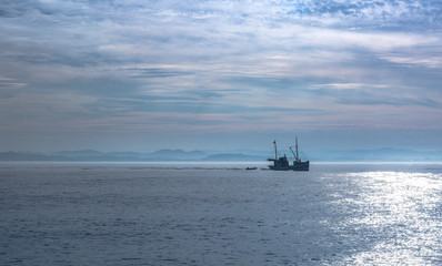 Fishing boat alone in sunrise lights