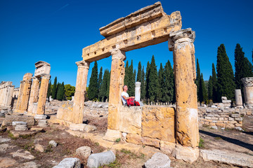 Obraz premium Happy tourist relaxes among antique ruins