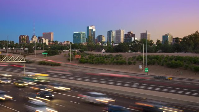 Phoenix Arizona Generic Skyline with Interstate Traffic Timelapse at Dusk with Streaking Lights from Moving Cars and the Cityscape under a Vibrant Colorful Night Sky