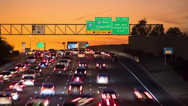 Phoenix AZ Interstate Rush Hour Vehicle Traffic Timelapse at Sunset with I17 Signage as Cars are Driving through Arizona under a Vibrant Orange Sky