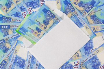 White envelope with money on the background of the new Russian two thousandth bills