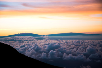 Fototapeta na wymiar Beautiful Colorful Sunrise Sky at Dawn from the Top of Haleakala Volcano in Maui Hawaii Above the Clouds with Mountains in Background of Amazing Landscape in Island Paradise