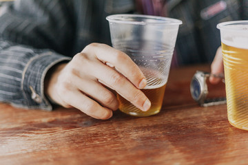 man hand holds an incomplete glass of beer