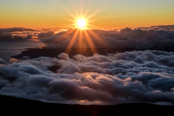Beautiful Colorful Sunset Sky at Dusk with Sun Rays Coming Through Clouds from the Top of Haleakala Volcano in Maui Hawaii with Mountains in Background of Amazing Landscape in Island Paradise