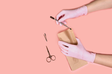 packing a manicure tool in kraft packages before sterilizing in a dry oven. Manicure tool in the...