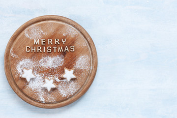 Christmas and Advent traditional almond gingerbread on wooden board .Top view, close-up.  Christmas, New Year concept on concrete light blue table.