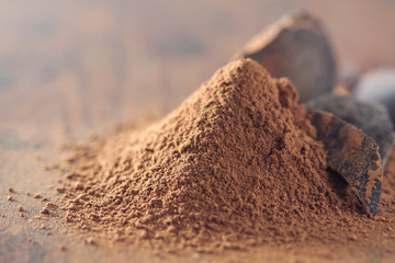 dark chocolate, cocoa solids and cocoa powder over wooden background