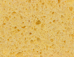 Yellow sponge texture background, close up macro view of a cosmetic sponge or pad for facial make up