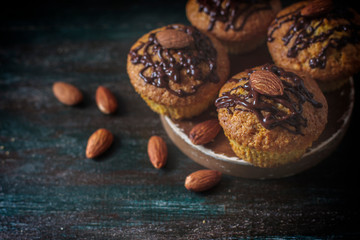 Muffins, cakes with almond nuts on a dark background. Copy space.